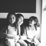 Three little girls sitting at a window